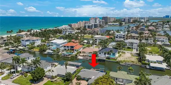 Image 3: Waterfront property with direct canal access, featuring a private dock and lush tropical landscaping