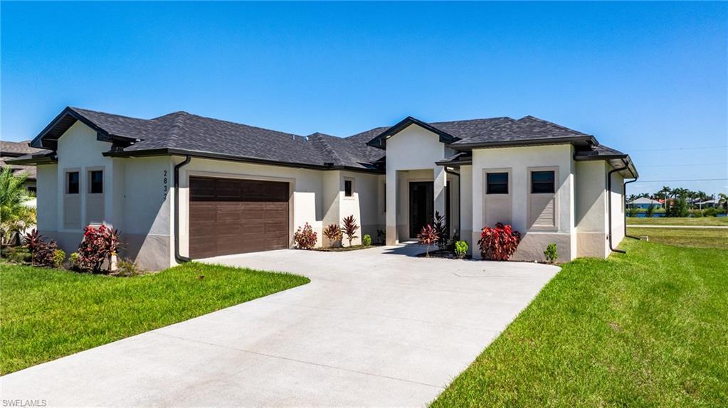 Image 1: Prairie-style home with a front lawn, stucco siding, and an attached garage