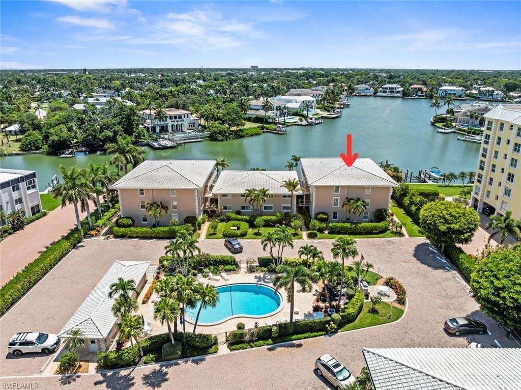 Image 2: Aerial perspective of a the Ambassador Club, a low rise residential building with a gabled roof, situated waterfront