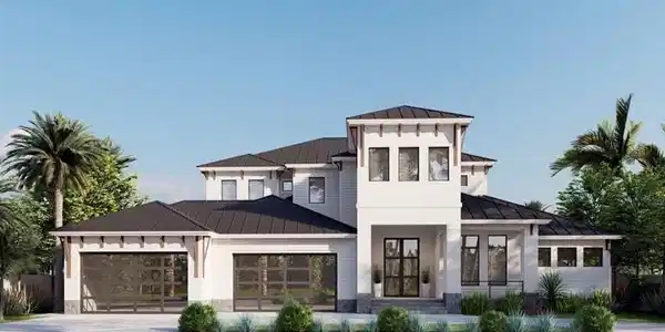 Image 3: View of front facade featuring a standing seam roof, a metal roof, an attached garage, driveway, and stone siding