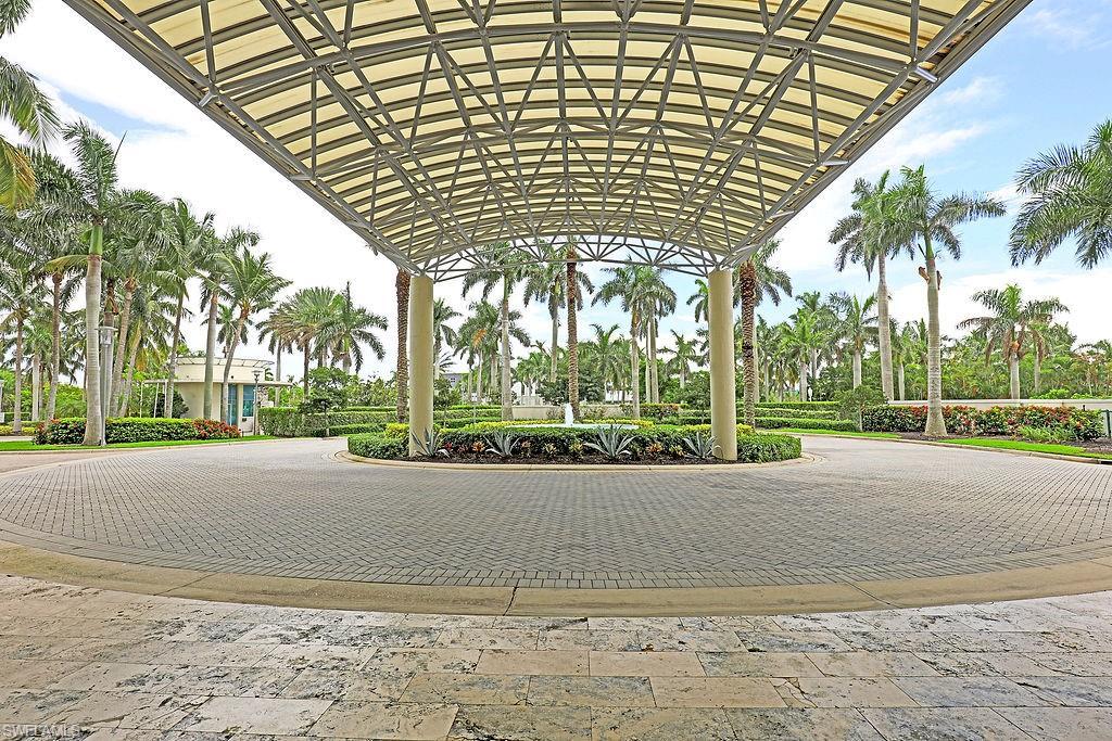 Image 3: Canopy-covered entryway featuring a circular paver driveway