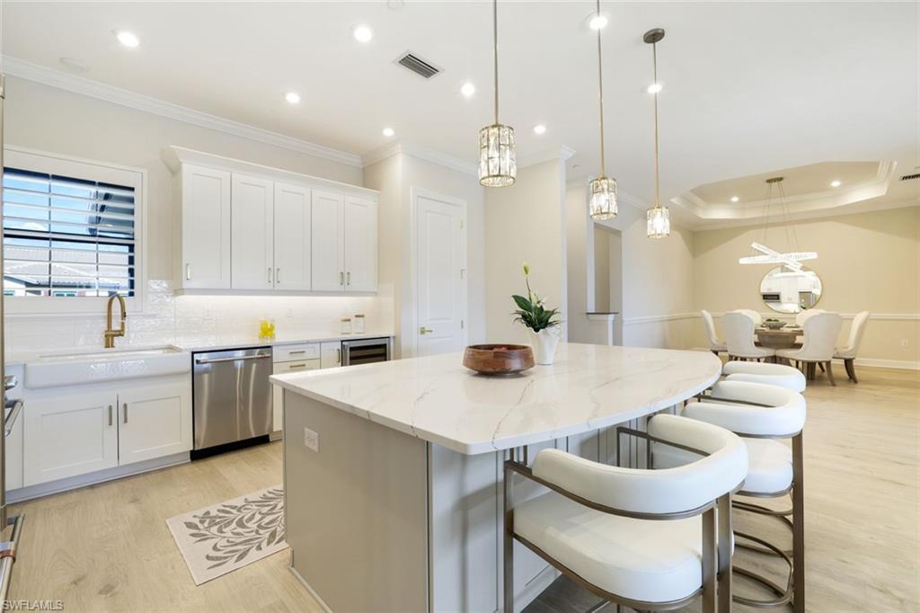 Image 2: Stunning gourmet kitchen featuring an oversized quartz island, premium appliances, and custom finishes.