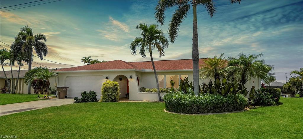 Image 2: Single-story stucco residence featuring an orange tile roof and a prominent curved front entrance with arched alcoves