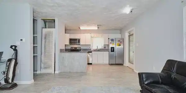 Image 3: Living room featuring baseboards and a textured ceiling