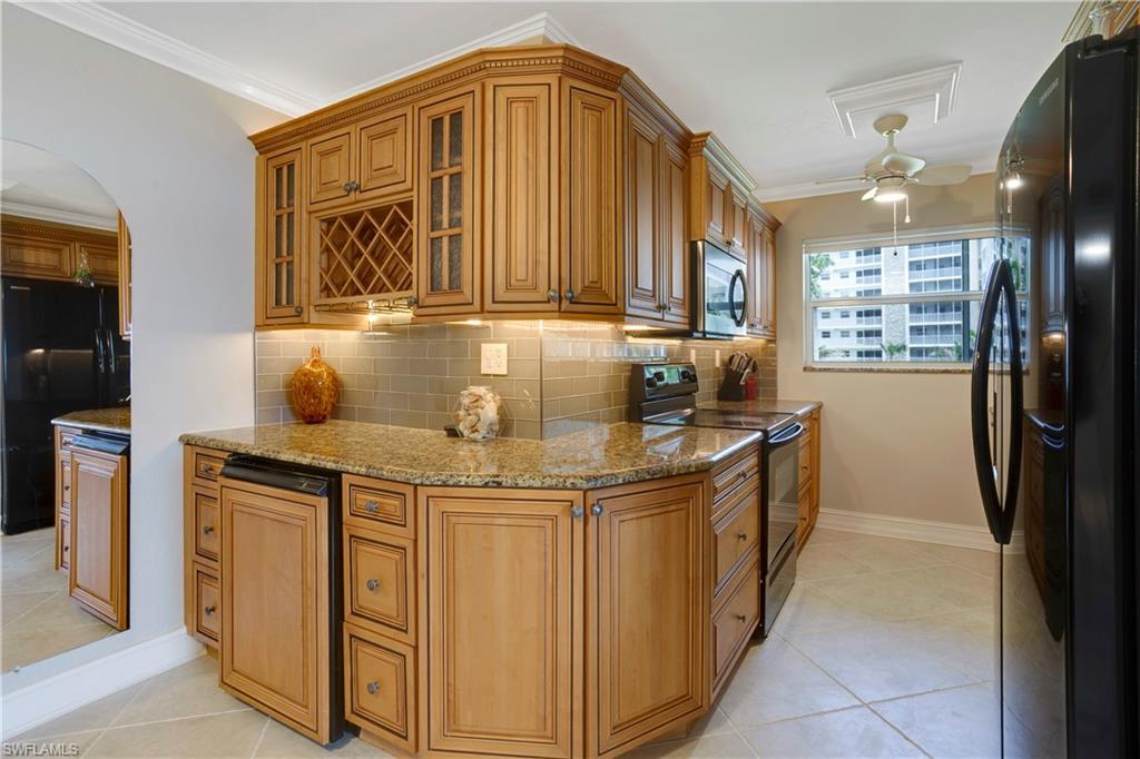 Image 3: Reconfigured kitchen with wine rack, glass cabinet doors, glass subway tile.