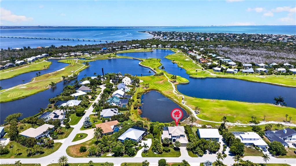 Image 2: Aerial perspective showcasing a residential property with a direct view of a water feature and golf course