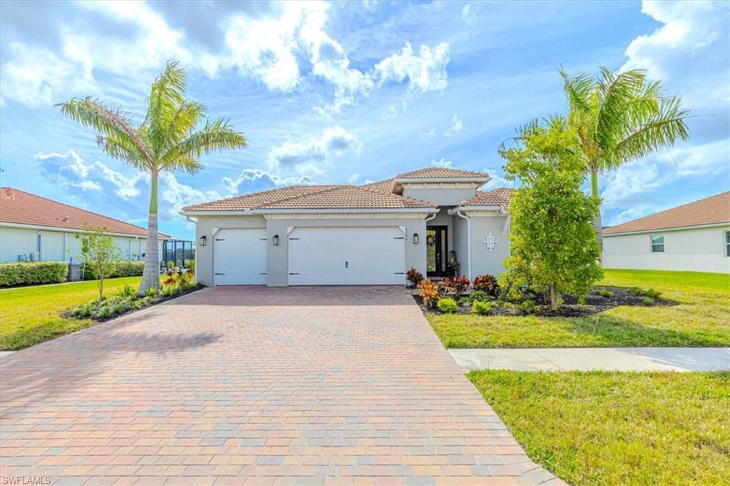 Image 3: Mediterranean / spanish-style home featuring a front yard, an attached garage, decorative driveway, and stucco siding