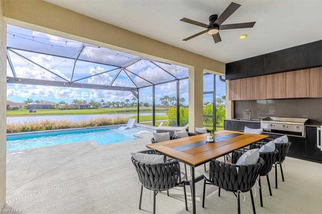 Image 4: Swimming pool with a sunroom, a patio area, area for grilling, a water view, and outdoor dining area