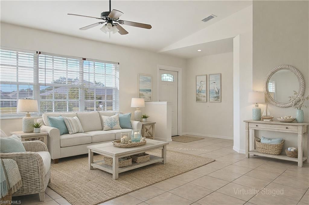 Image 4: Spacious living area featuring large windows with horizontal blinds, tiled flooring, a ceiling fan with integrated lighting, and neutral wall tones