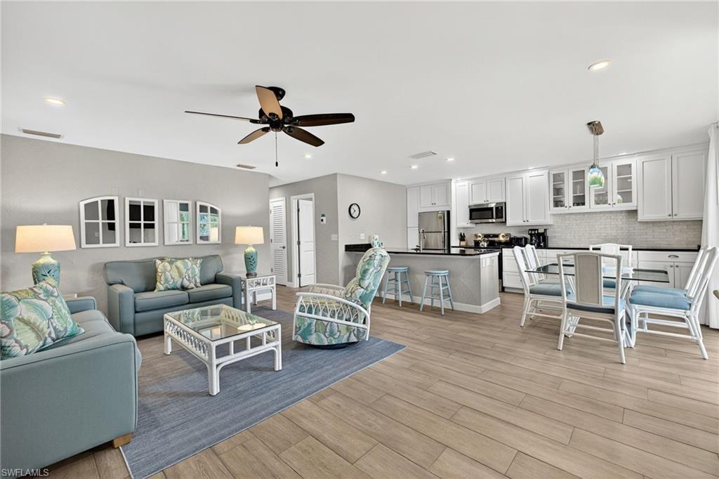 Image 4: Living room with light wood-style floors, recessed lighting, and a ceiling fan