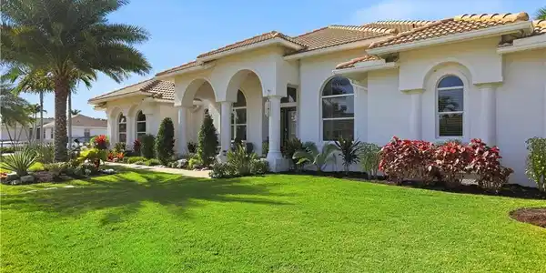 Image 2: View of property exterior featuring a yard, stucco siding, and a tiled roof