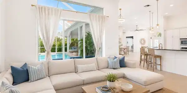 Image 4: Spacious living area featuring high ceilings and large glass sliders