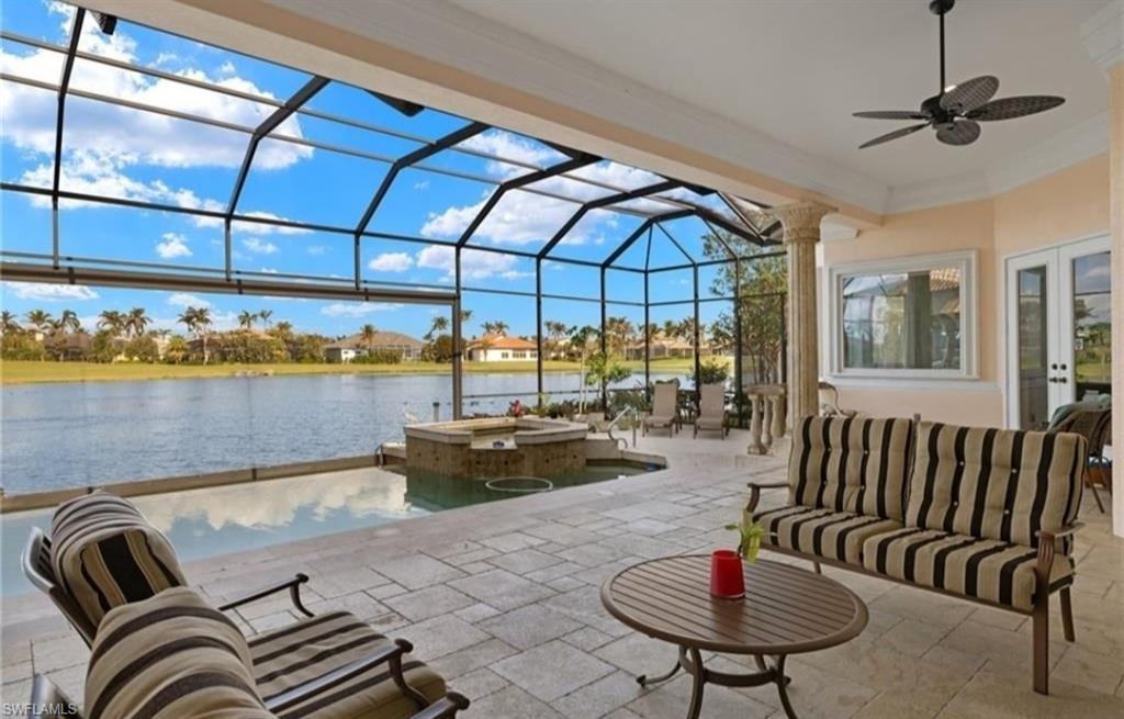 Image 2: View of patio / terrace with a sunroom, a pool with connected hot tub, ceiling fan, a lanai, and a water view