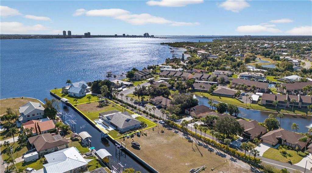 Image 3: Aerial perspective of suburban area featuring property boundaries highlighted and a nearby body of water