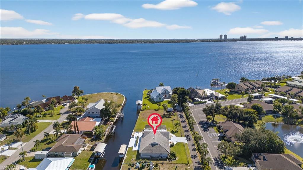 Image 4: Aerial view of property's location featuring a large body of water and nearby suburban area