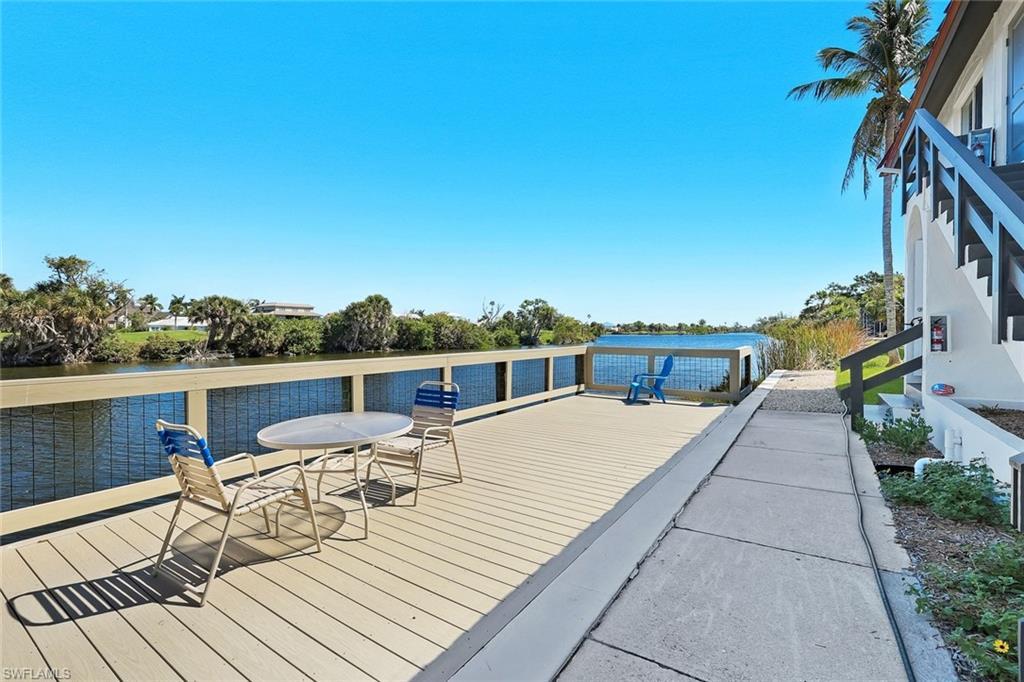 Image 3: Waterfront deck featuring a composite surface, white railing with mesh infill, and a palm tree