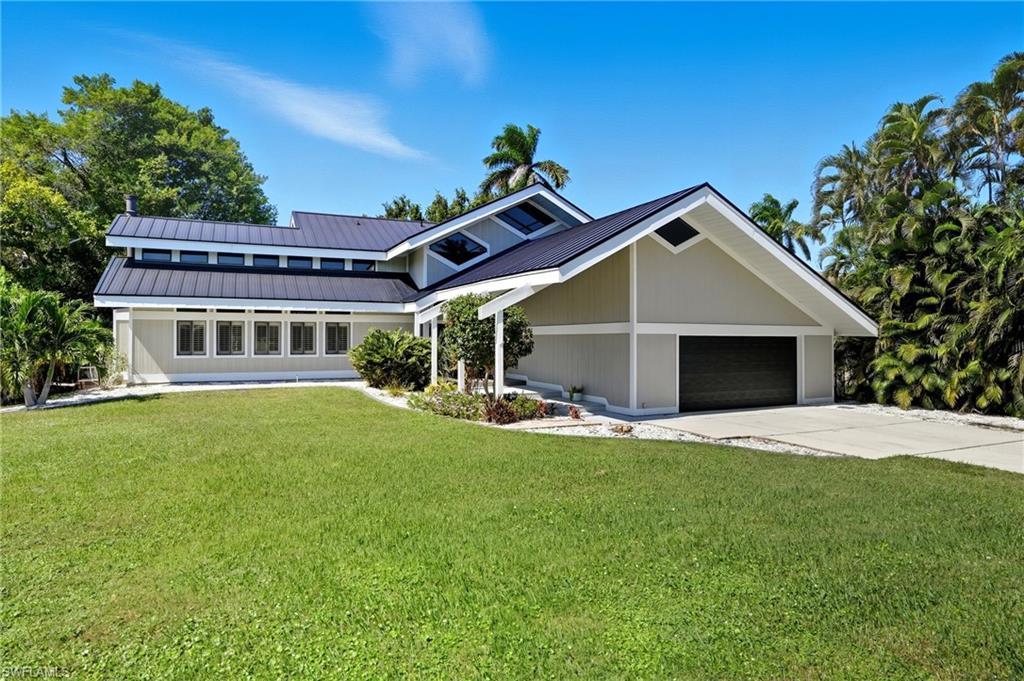 Image 2: Contemporary exterior with a dark metal roof and light-toned siding