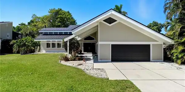 Image 3: Contemporary exterior featuring a gabled roofline, metal roof, and an integrated two-car garage