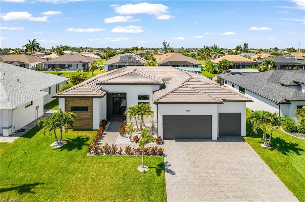 Image 2: Modern single-story residence featuring a tile roof and clean white exterior