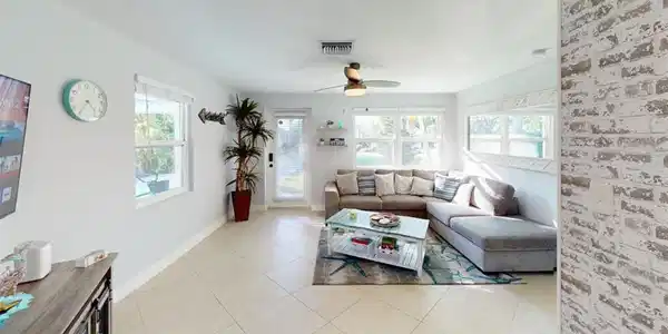 Image 4: Living area with a ceiling fan and light tile patterned floors