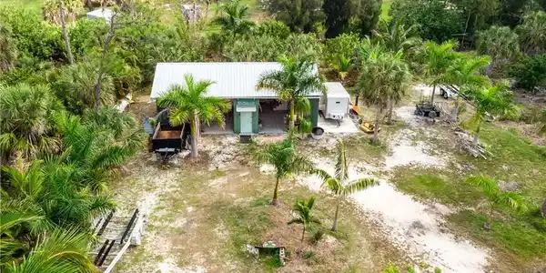 Image 3: North overhead facing view of fruit trees, palms and more that surround the barn.