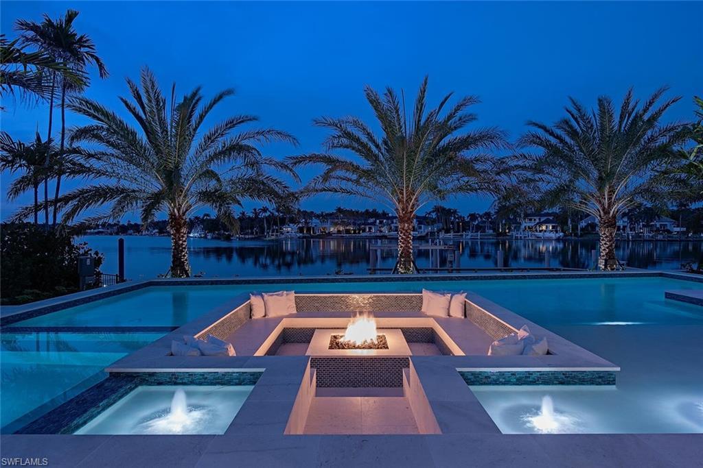 Image 2: Pool featuring a water view, an in ground hot tub, and an outdoor fire pit