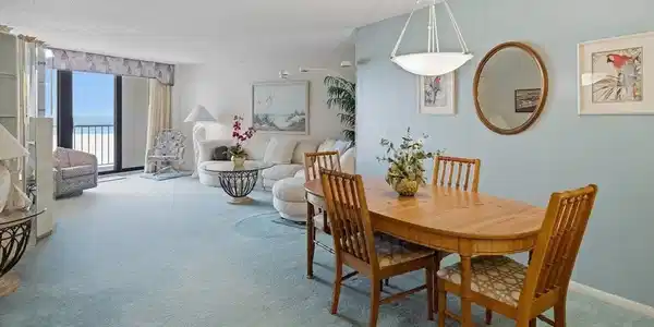 Image 3: Open-concept living and dining areas with expansive floor-to-ceiling windows, a wood dining table, and a contemporary pendant light fixture
