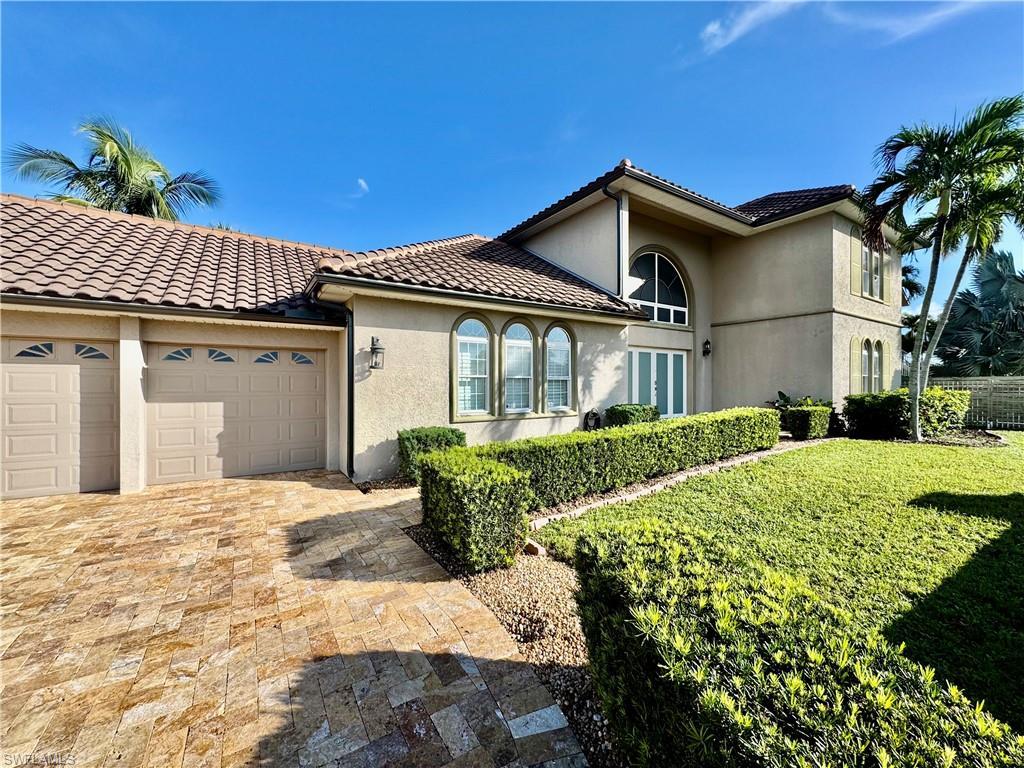 Image 3: Mediterranean / spanish house featuring an attached garage, stucco siding, driveway, and a tiled roof