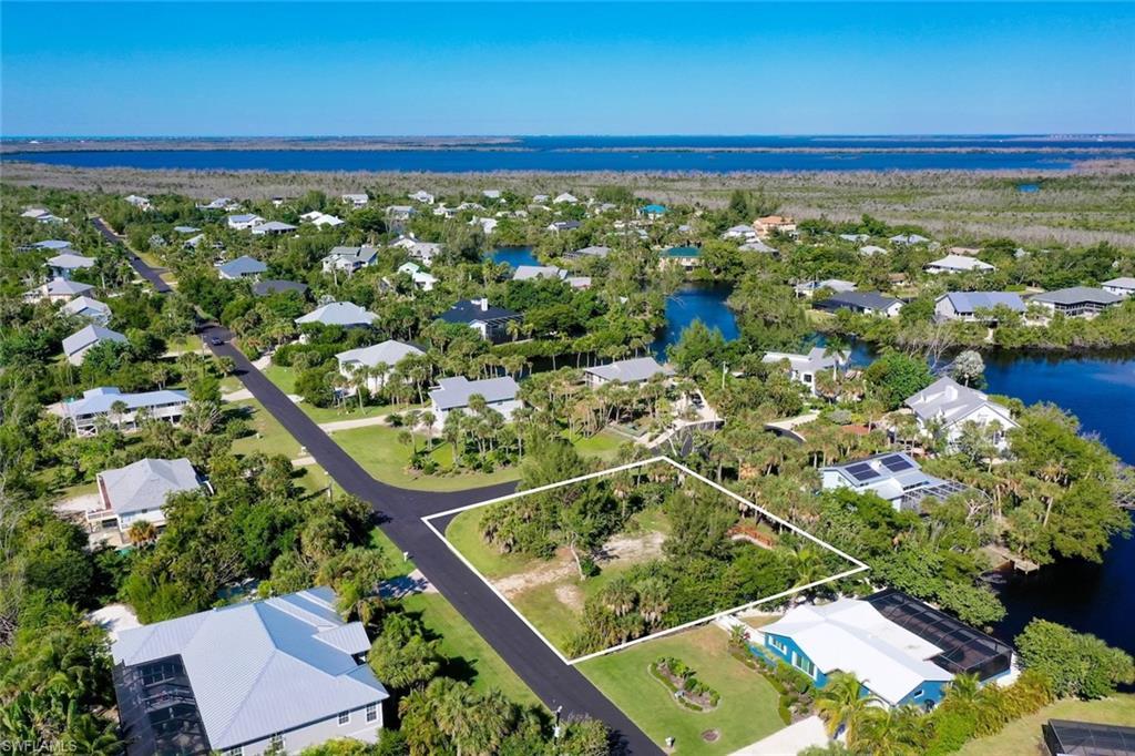 Image 3: Aerial view of residential area featuring a nearby body of water and property boundaries highlighted