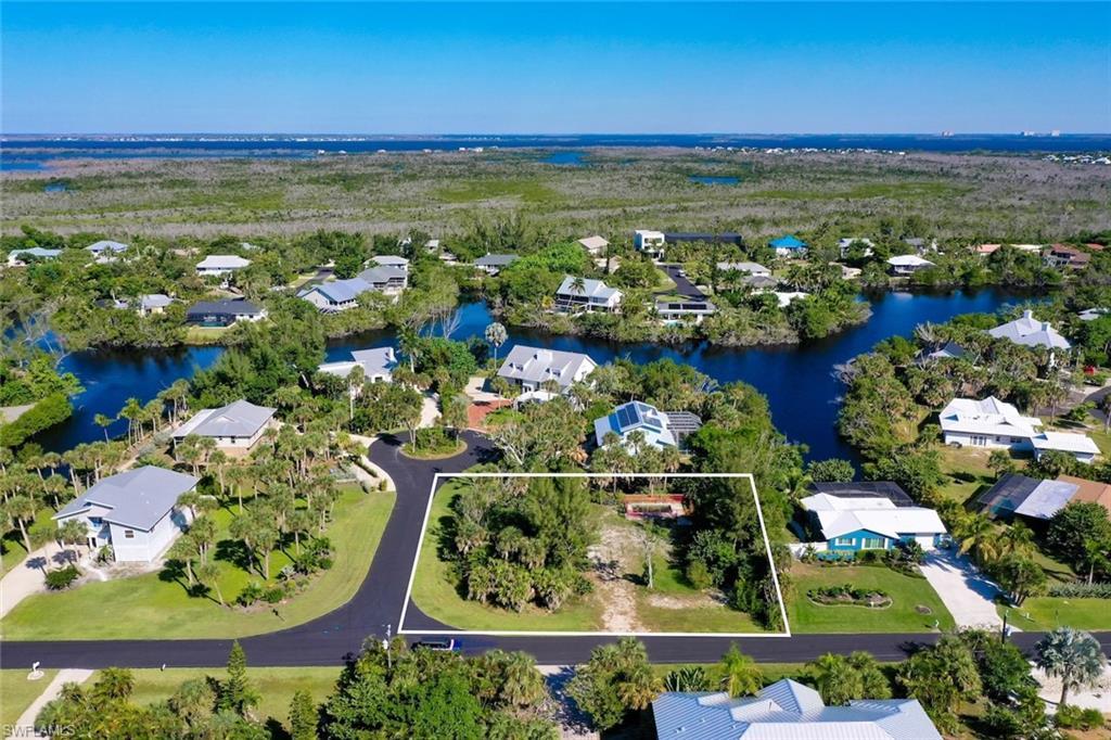 Image 4: Aerial view of residential area with property parcel outlined and a nearby body of water