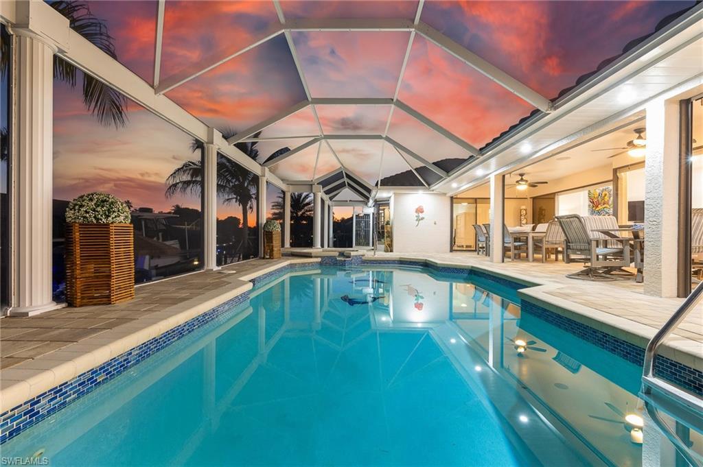 Image 3: View of pool with a sunroom and a pool with connected hot tub