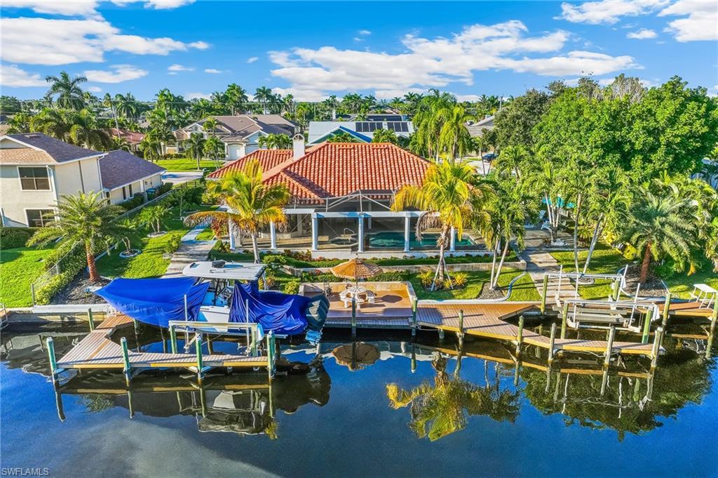 Image 4: Dock area featuring boat lift, a water view, a residential view, and a patio area