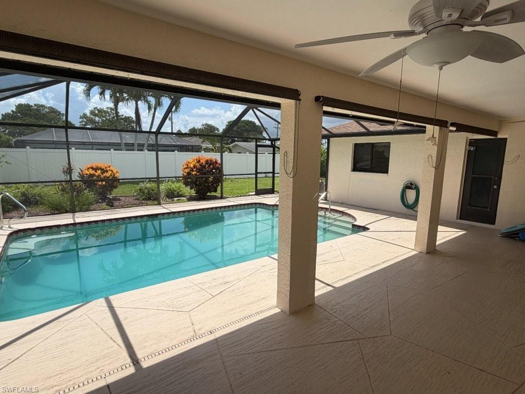 Image 3: Screened-in pool area featuring a rectangular pool with an attached spa