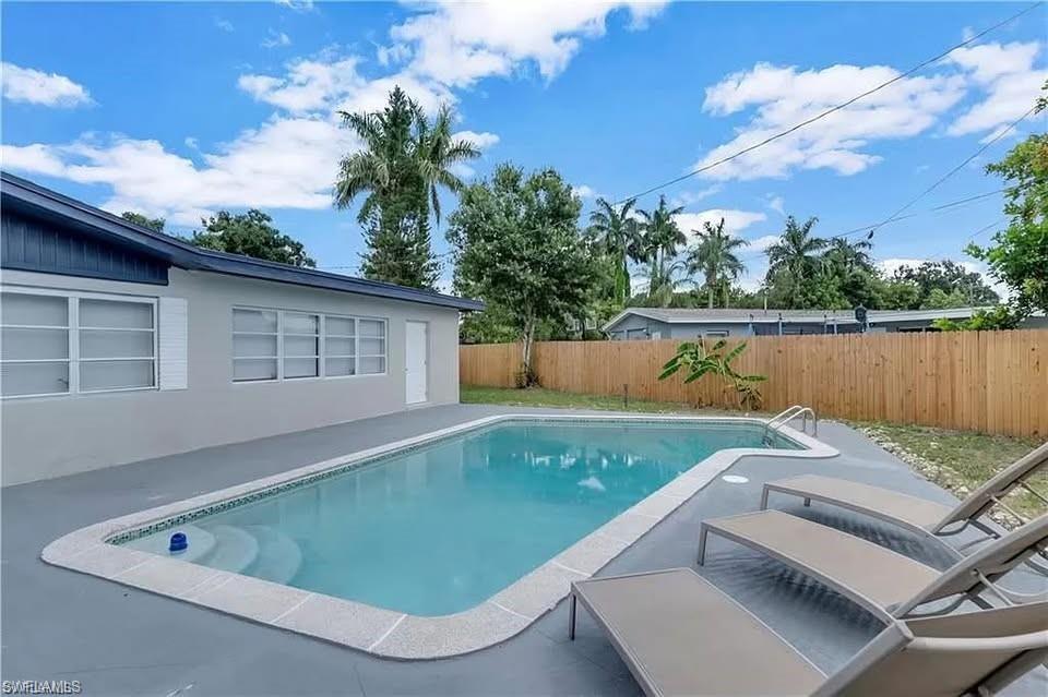 Image 2: View of pool featuring a fenced backyard and a patio area