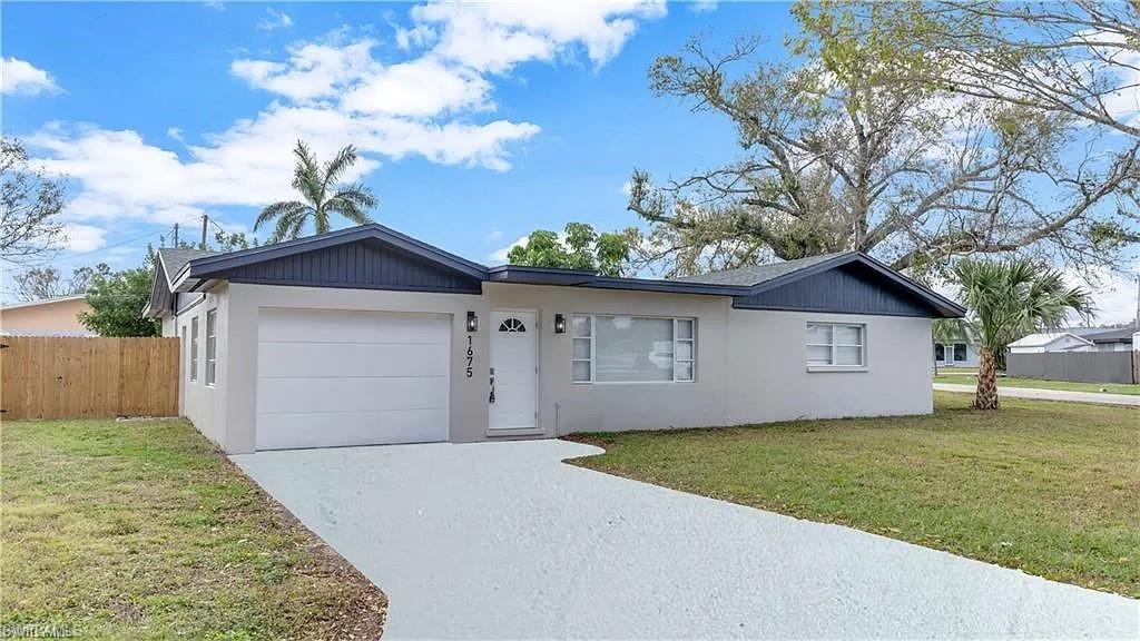 Image 4: Single story home with stucco siding, an attached garage, and driveway