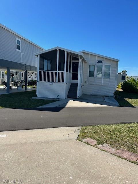 Image 3: Manufactured / mobile home with a sunroom and a front yard