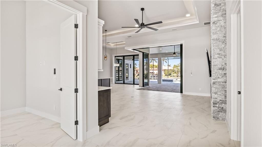 Image 3: Foyer entrance with a raised ceiling, ceiling fan, and french doors