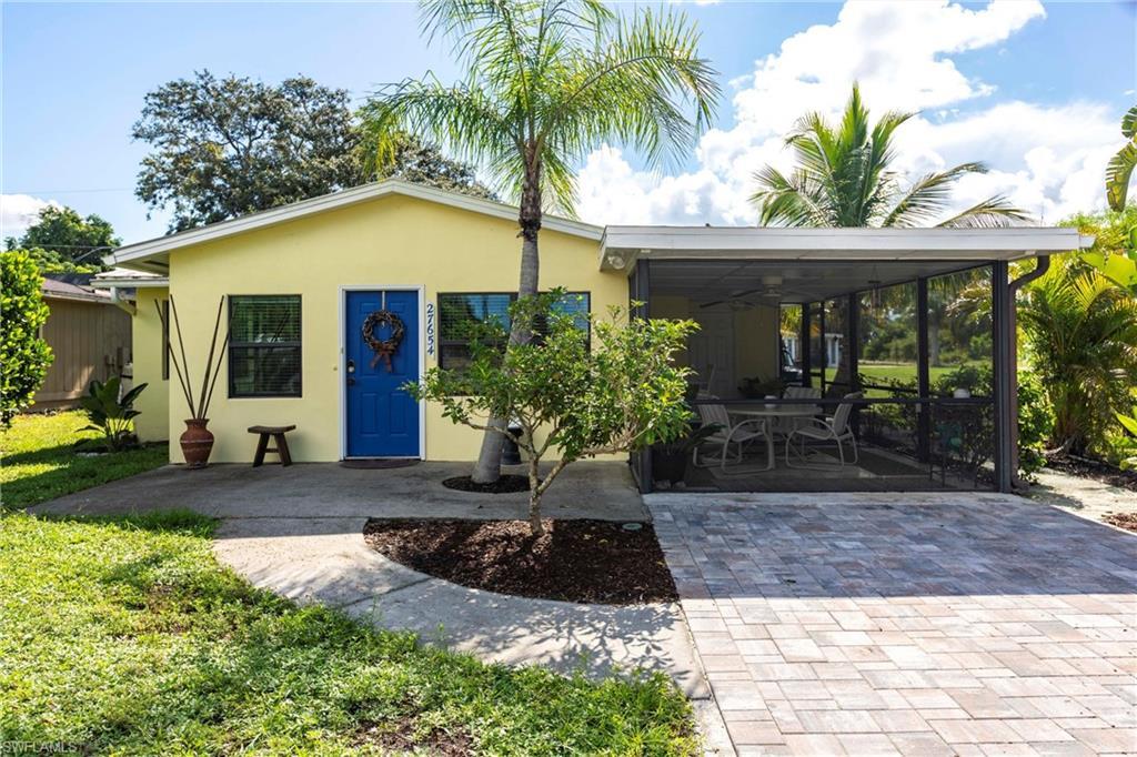 Image 1: View of front facade featuring an attached carport, stucco siding, NEW driveway, and a sunroom