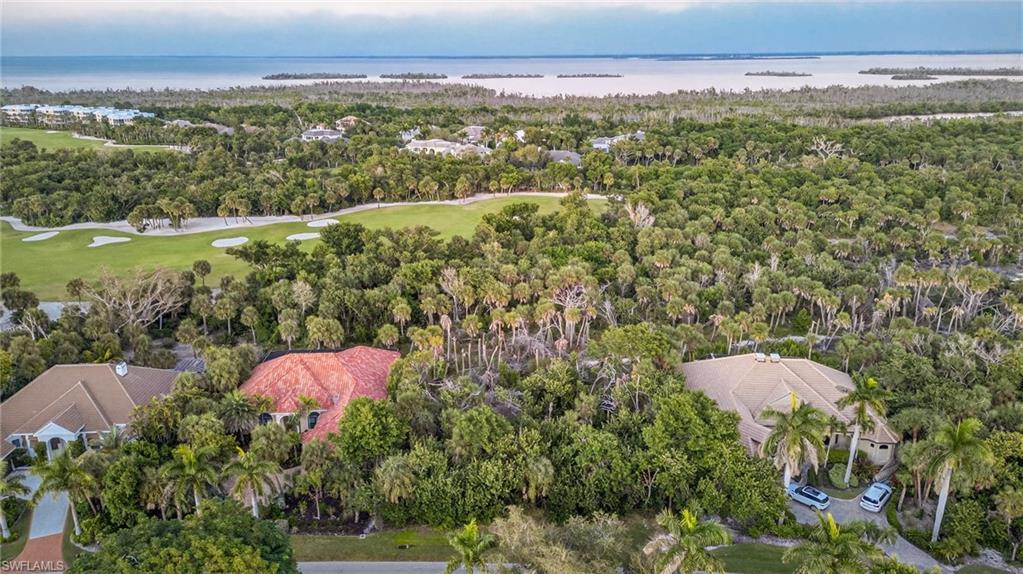 Image 1: Aerial view of residential area featuring a nearby body of water and a local golf course