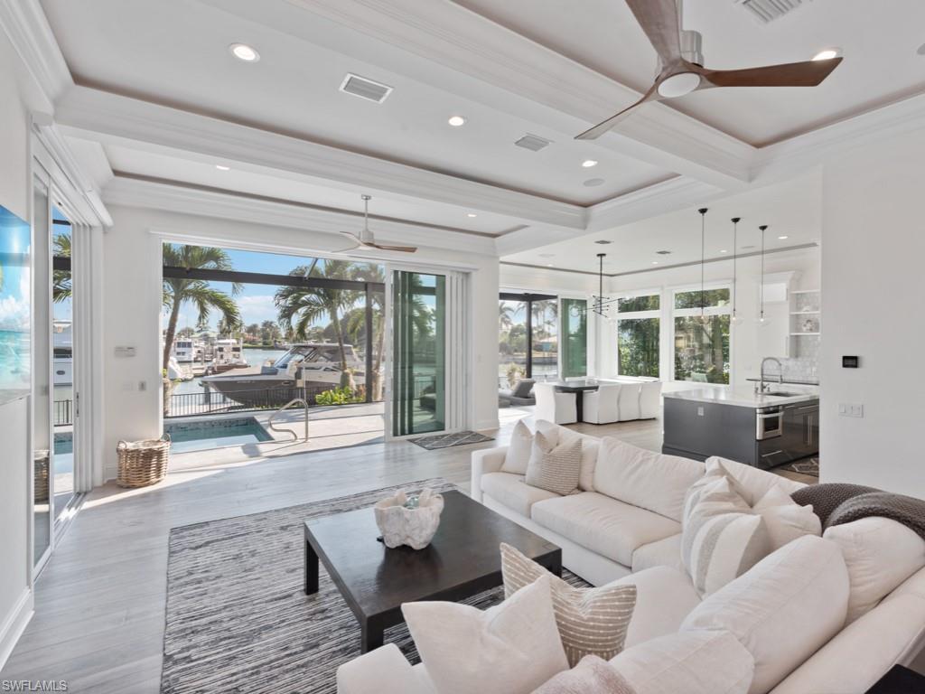 Image 3: Living room with hardwood / wood-style floors, ceiling fan, beamed ceiling, crown molding, and sink