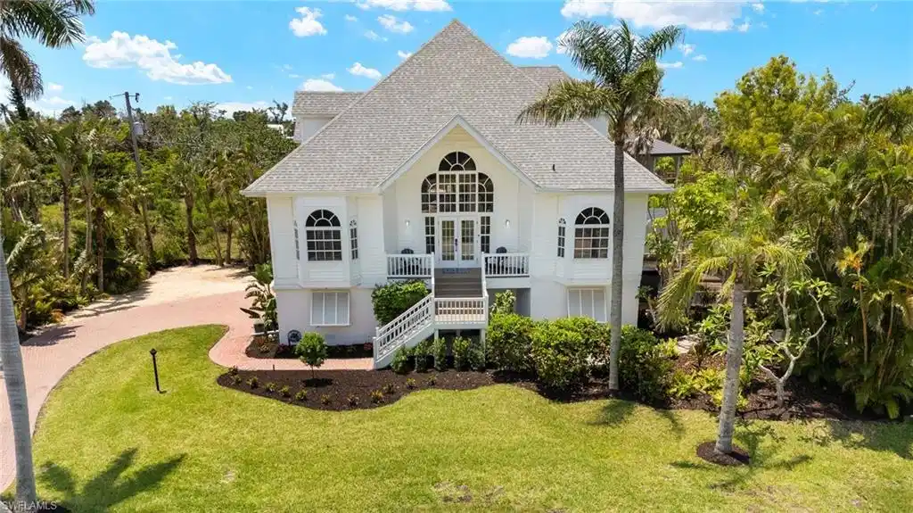 Image 1: View of front of home with stairway, french doors, a front lawn, a shingled roof, and a balcony