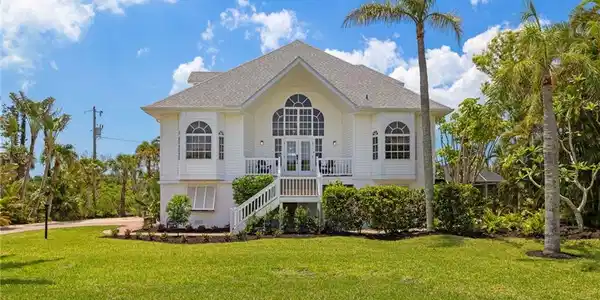 Image 3: Front view of house featuring a lawn, roof with shingles, stairway, and a balcony