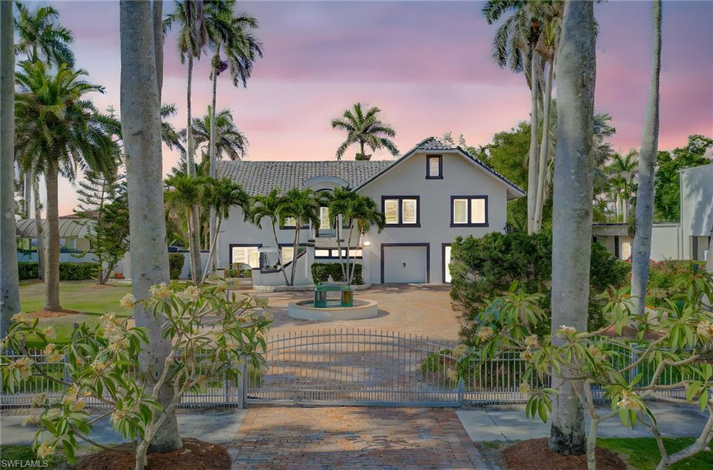 Image 2: View of front of home featuring a tile roof, stucco siding, a garage, and decorative driveway