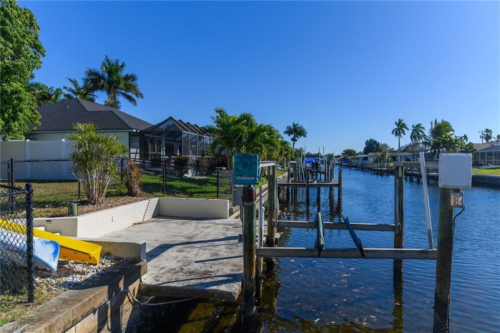Image 3: Dock featuring a water view, boat lift, a lanai, and a sunroom
