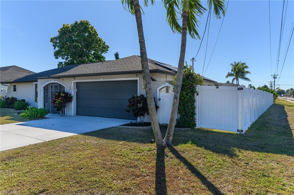 Image 4: View of front of home with stucco siding, driveway, and a garage