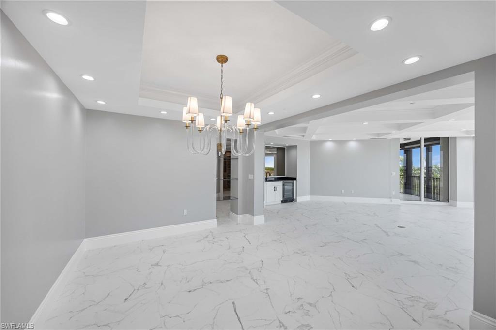 Image 4: Unfurnished room with a tray ceiling, baseboards, recessed lighting, and a chandelier