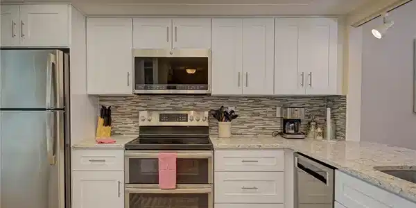 Image 3: Kitchen featuring stainless steel appliances and white cabinets