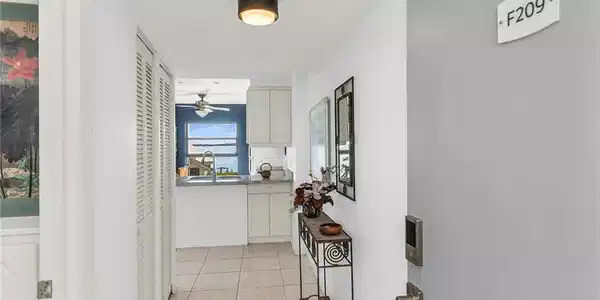 Image 3: Hallway with a sink and light tile patterned flooring