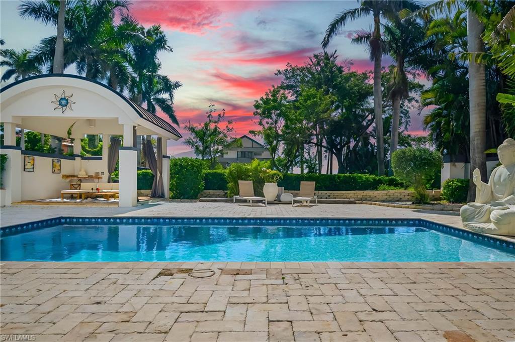 Image 3: Pool at dusk featuring a gazebo, an outdoor pool, and a patio