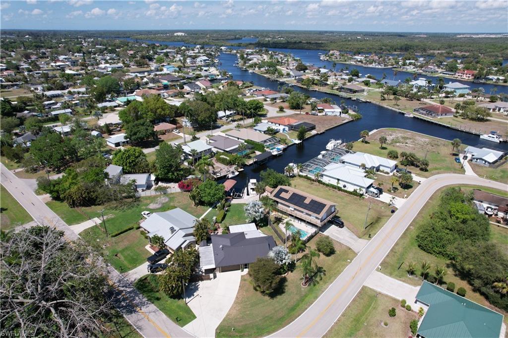 Image 3: Aerial view of property and surrounding area featuring nearby suburban area and a large body of water